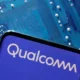 Qualcomm logo on smartphone, circuit board background