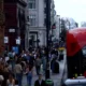 Busy London street with red bus and pedestrians.