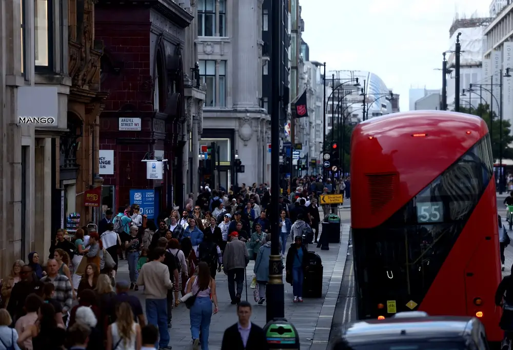 Busy London street with red bus and pedestrians.