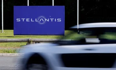 Stellantis sign with passing car in foreground.