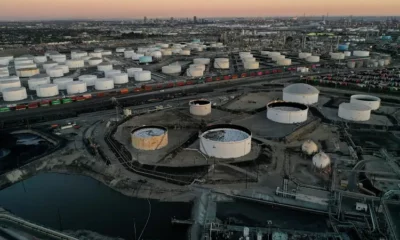 Aerial view of industrial oil storage tanks at sunset.