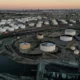 Aerial view of industrial oil storage tanks at sunset.