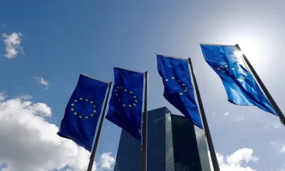 EU flags flying outside tall building