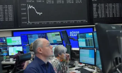 Traders monitor stock market data on multiple screens.