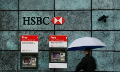 Person with umbrella at HSBC cash machines.