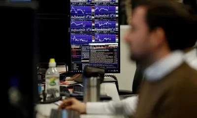 Man analysing stock charts on multiple screens