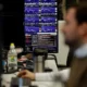 Man analysing stock charts on multiple screens