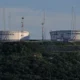 Large oil storage tanks with antennas nearby.