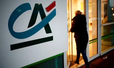 Person entering building with CA logo on wall.