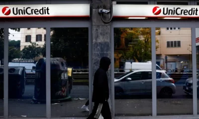 Person walking past a UniCredit bank branch.