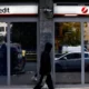 Person walking past a UniCredit bank branch.