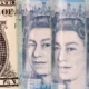 US dollar and UK pound currency notes closeup.