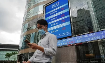 Man on phone outside stock exchange building