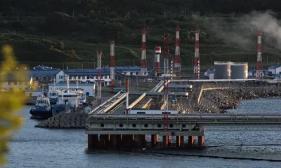 Oil facility with docks and storage tanks in background.