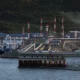 Oil facility with docks and storage tanks in background.