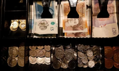 Open cash register with British coins and notes.