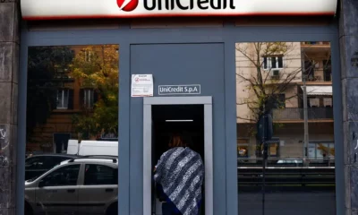 Person using UniCredit ATM machine.