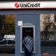 Person using UniCredit ATM machine.