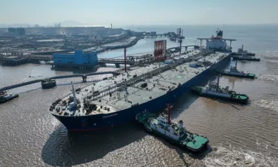 Large tanker ship docking at industrial port.