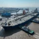 Large tanker ship docking at industrial port.