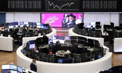 Stock exchange trading floor with data screens.