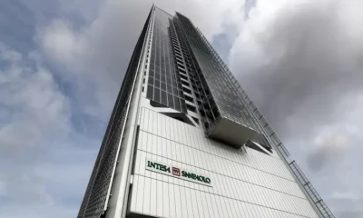 Tall skyscraper under cloudy sky, Intesa Sanpaolo logo visible.