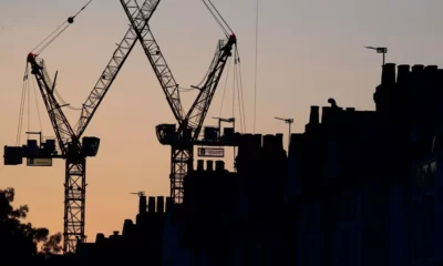 Silhouette of construction cranes at dusk