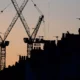 Silhouette of construction cranes at dusk