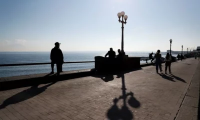 People walking along sunny seaside promenade