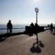 People walking along sunny seaside promenade