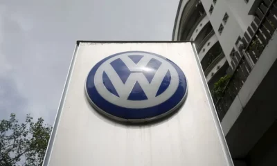 Volkswagen logo on a tall signboard outside building.