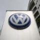 Volkswagen logo on a tall signboard outside building.