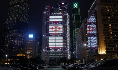 Illuminated skyscrapers in city skyline at night.