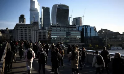 Crowded walkway with London skyscrapers in background.