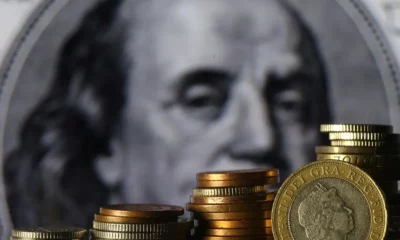 Stacks of coins in front of currency portrait.