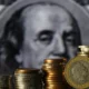 Stacks of coins in front of currency portrait.