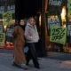 Women walking past Black Friday sale signs.