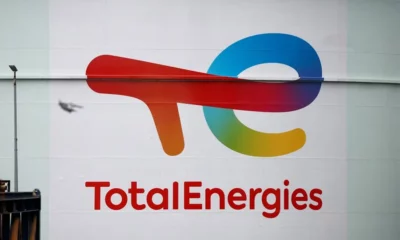 TotalEnergies logo on building with passing bird