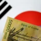 Korean won banknote with South Korea flag background.