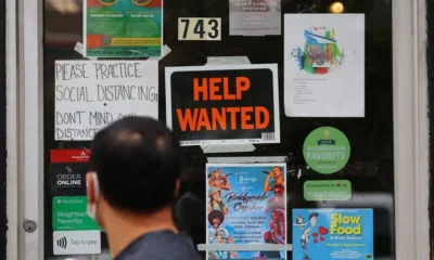 Storefront with help wanted and event posters.