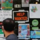 Storefront with help wanted and event posters.