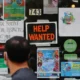 Shop window with help wanted and event posters.