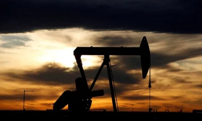 Oil pumpjack silhouetted against sunset sky