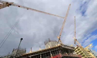 Cranes working on city building construction site.