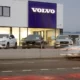 Volvo dealership with parked cars and showroom display.