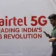 Man walking past Airtel 5G advertisement banner.