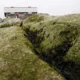 Moss-covered rocks with building in the distance