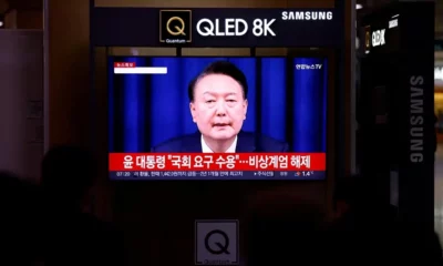 Samsung QLED TV showing news broadcast.