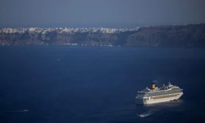 Cruise ship near Santorini island coastline in Greece.