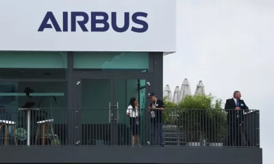 Airbus building exterior with people on balcony.